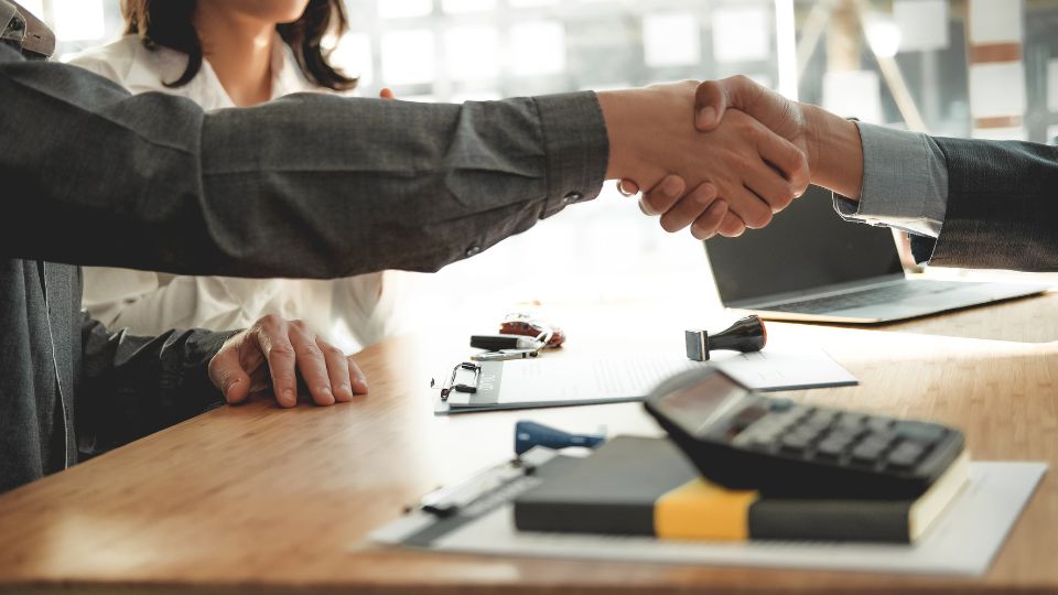 A man shaking hands with a broker over a real estate deal 