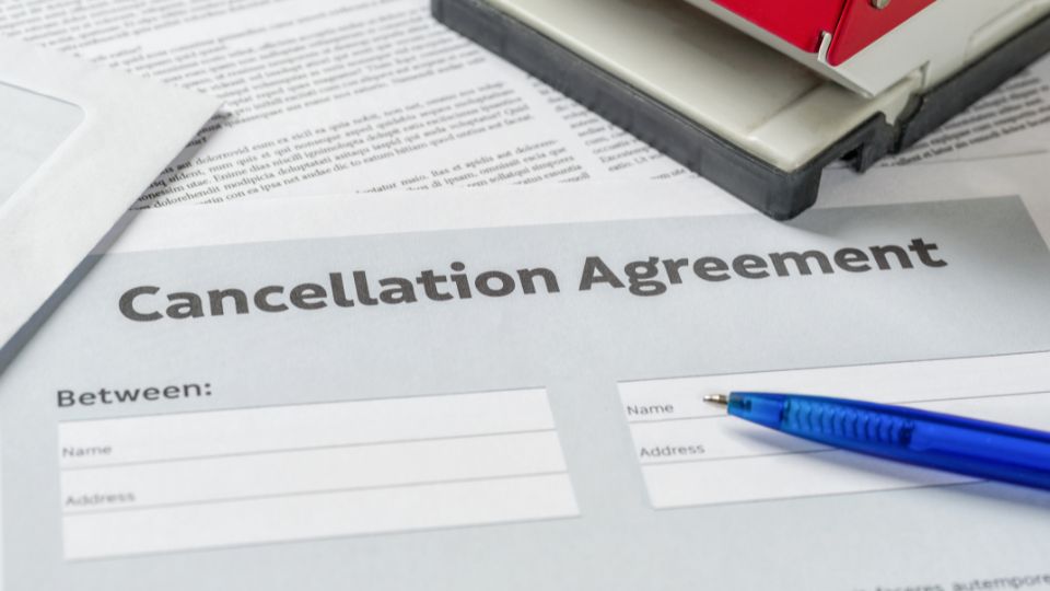 A paper with cancellation agreement written on top with a blue pen 