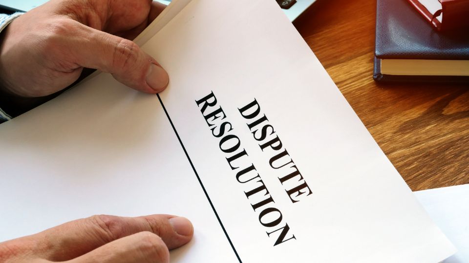 A person reading a paper with Dispute Resolution written on top of it